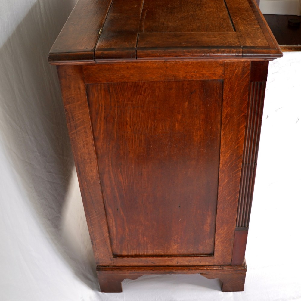 A Georgian oak and mahogany crossbanded Lancashire mule chest with brass handles and bracket feet. View IV