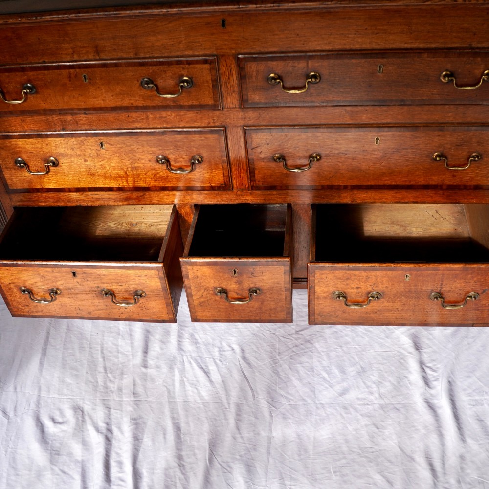 A Georgian oak and mahogany crossbanded Lancashire mule chest with brass handles and bracket feet. View VI