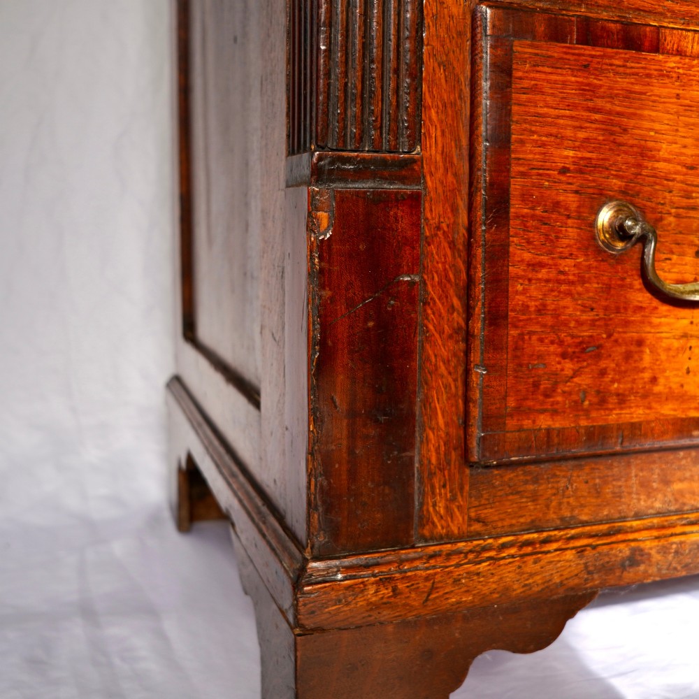 A Georgian oak and mahogany crossbanded Lancashire mule chest with brass handles and bracket feet. View X