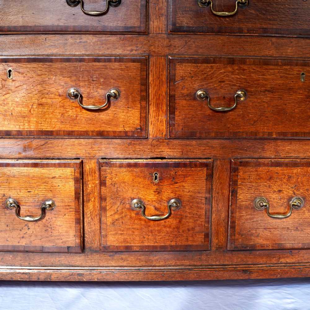 A Georgian oak and mahogany crossbanded Lancashire mule chest with brass handles and bracket feet. View XII