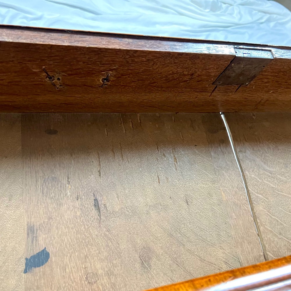 An eighteenth-century early Georgian figured walnut escritoire featuring an open fall-front revealing a detailed fitted interior above a lower chest of drawers with brass handles. View XI