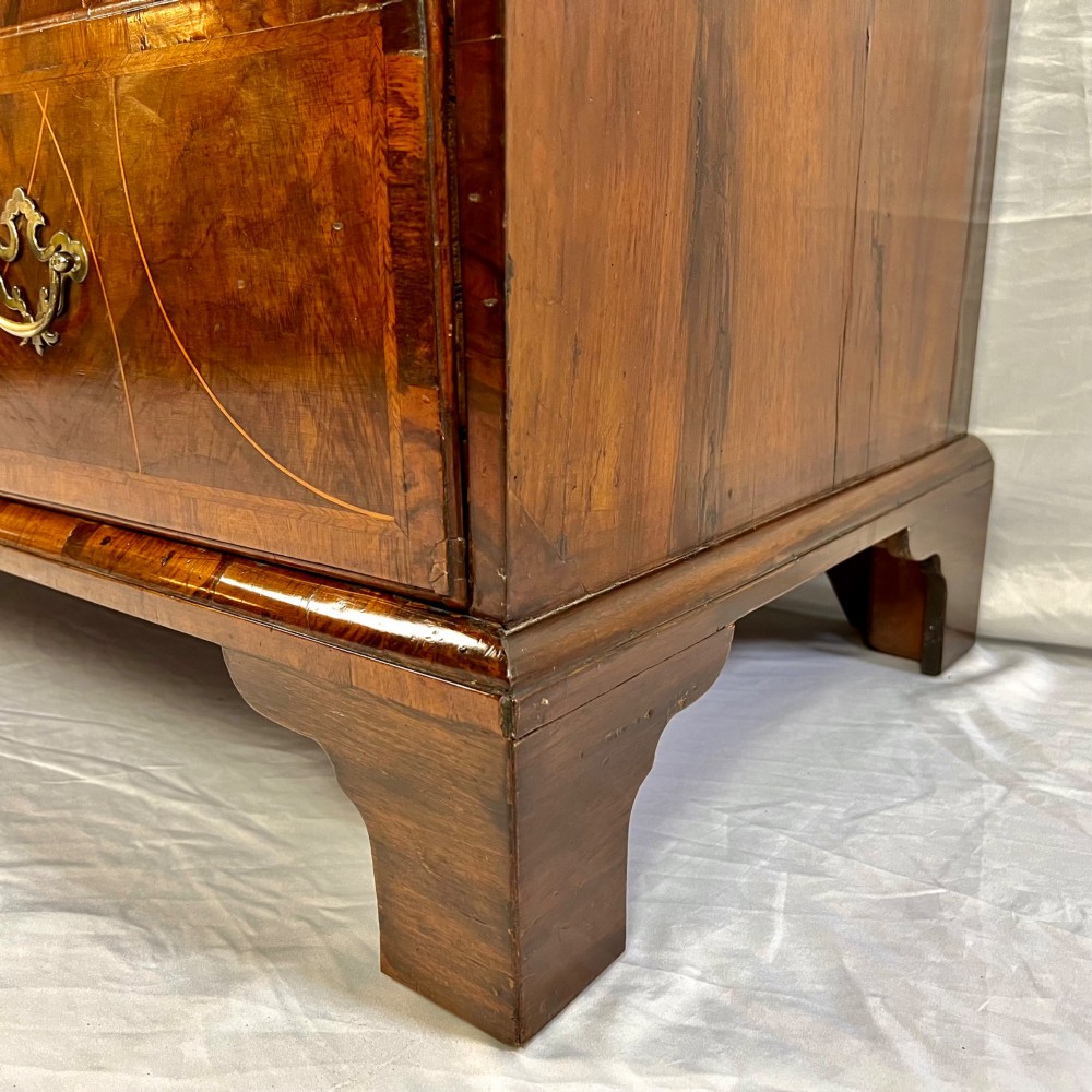 A tall George II two-part walnut chest on chest featuring figured burr walnut drawer fronts with line inlay, brass swan-neck handles, and bracket feet. View IX