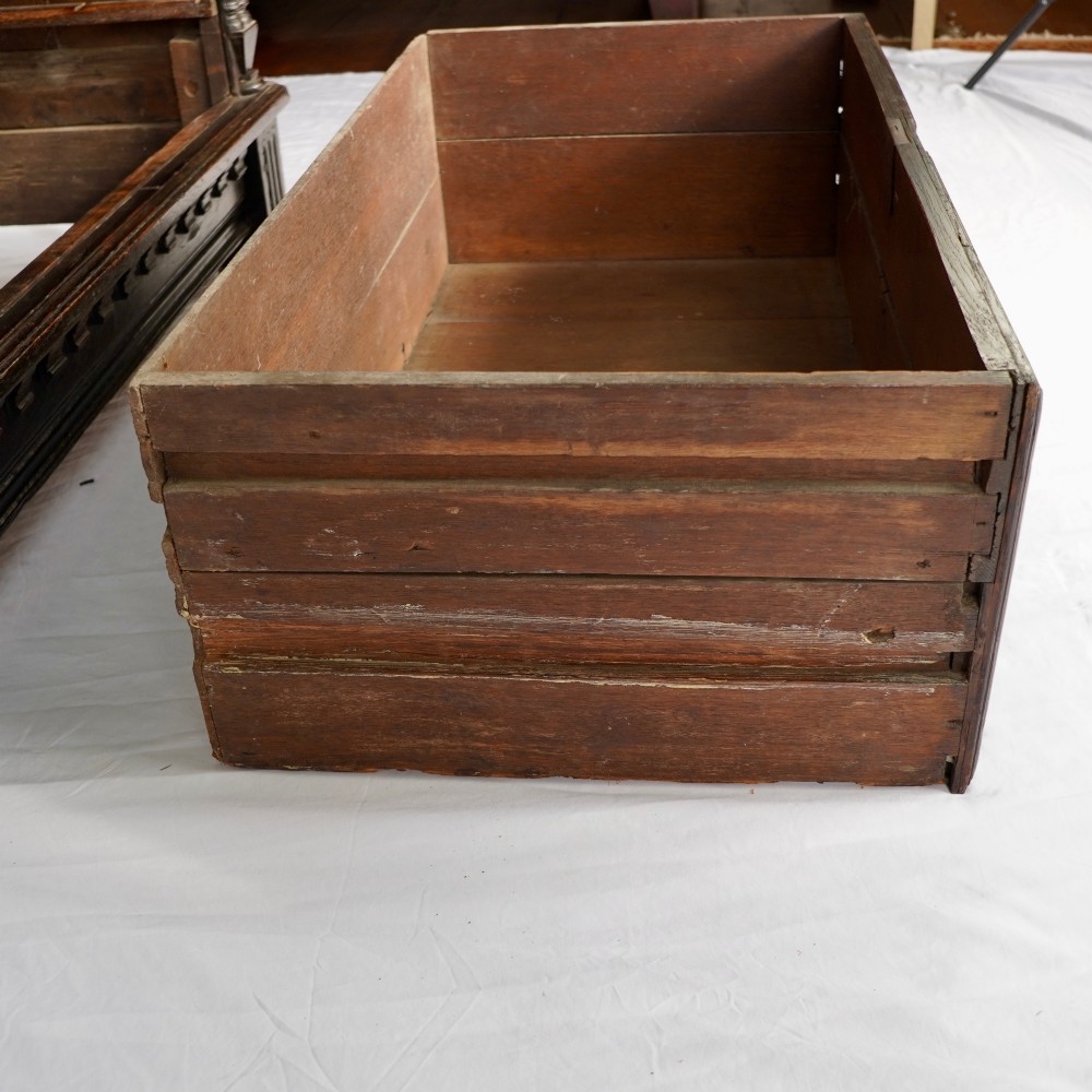 A dark oak 17th-century style chest of drawers featuring geometric timber inlay along the top frieze, applied mouldings, and brass drop handles. View VI