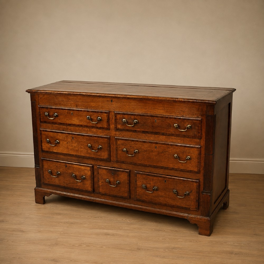 A Georgian oak and mahogany crossbanded Lancashire mule chest with brass handles and bracket feet. View XIV