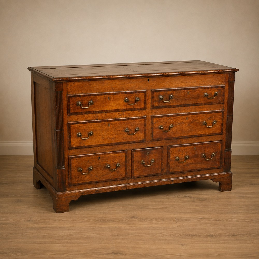 A Georgian oak and mahogany crossbanded Lancashire mule chest with brass handles and bracket feet. View XV