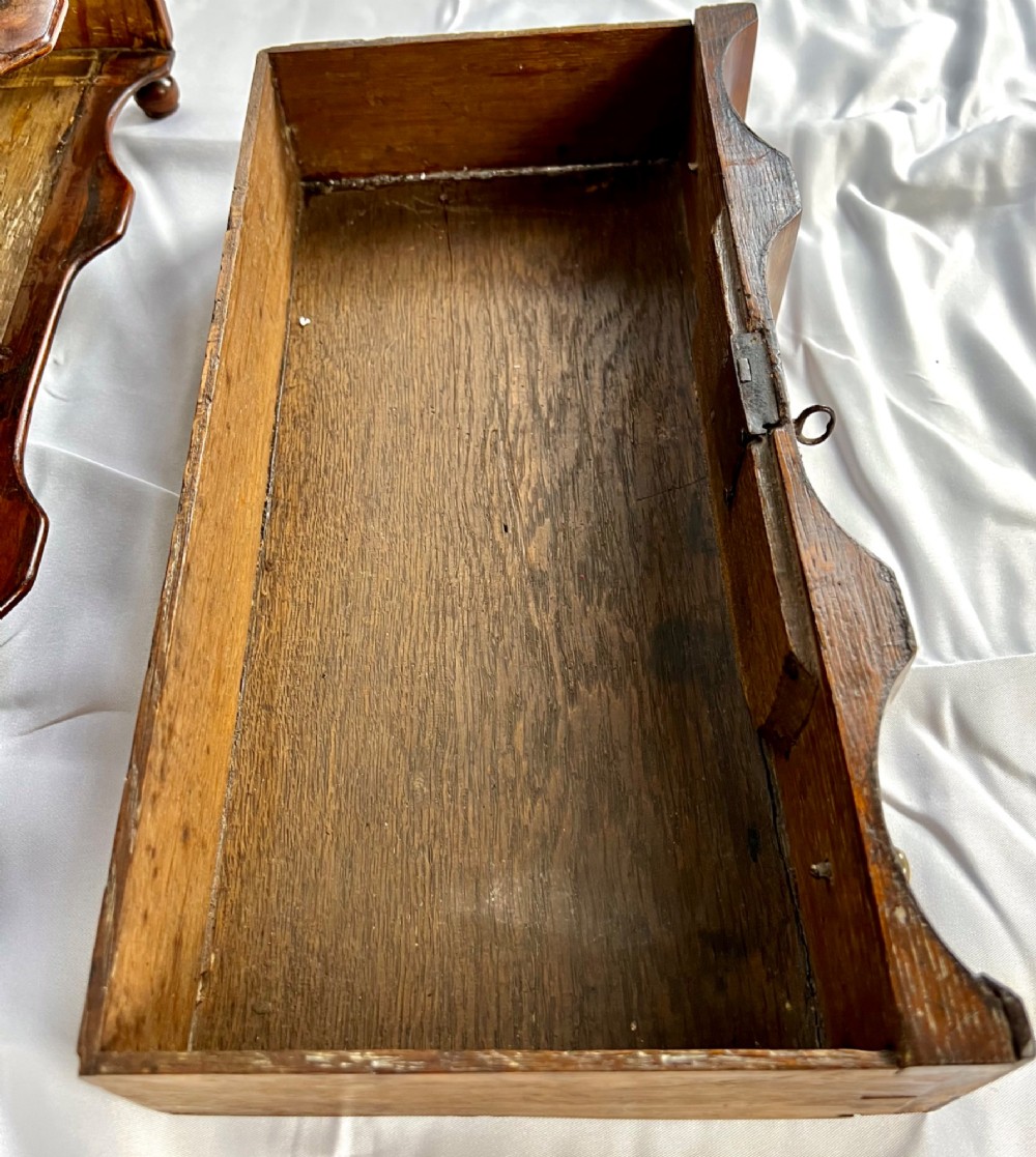 An antique Queen Anne walnut and laburnum toilet mirror featuring an arched cross-banded frame above a serpentine base with miniature drawers. View VI