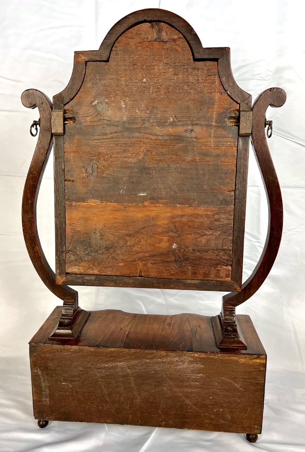 An antique Queen Anne walnut and laburnum toilet mirror featuring an arched cross-banded frame above a serpentine base with miniature drawers. View XI