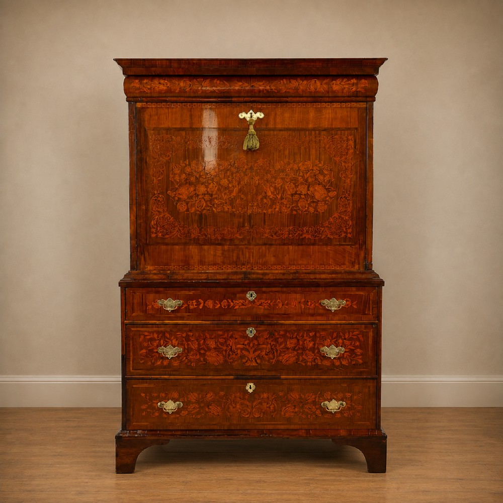 A tall Georgian walnut escritoire bureau featuring floral marquetry inlay on the fall-front flap and lower drawers with brass drop handles.