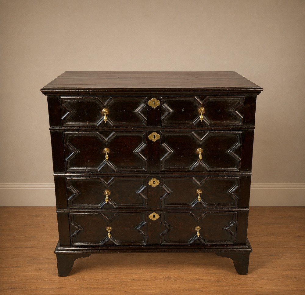 A dark oak Charles II chest of drawers featuring four geometric moulded drawer fronts with brass teardrop handles and decorative brass escutcheons. View XIV