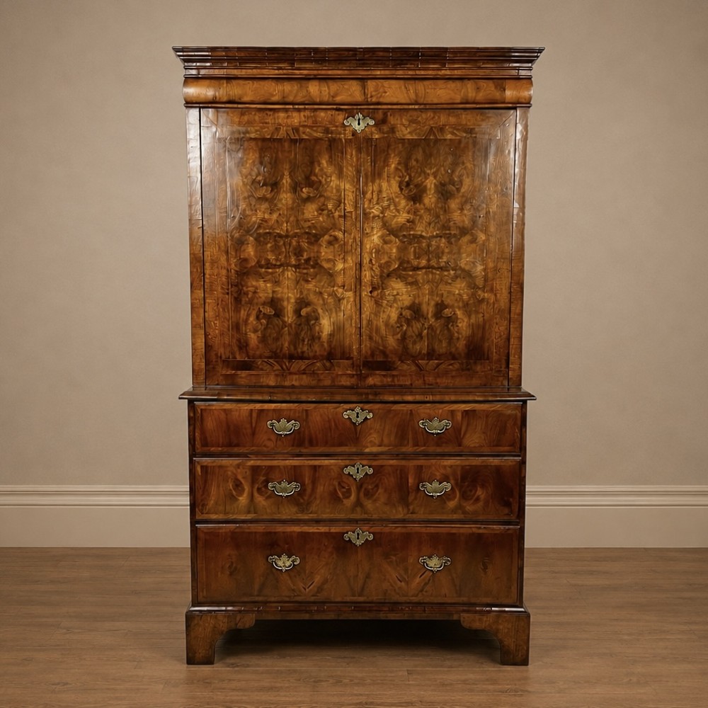 An eighteenth-century early Georgian figured walnut escritoire featuring an open fall-front revealing a detailed fitted interior above a lower chest of drawers with brass handles. View XV