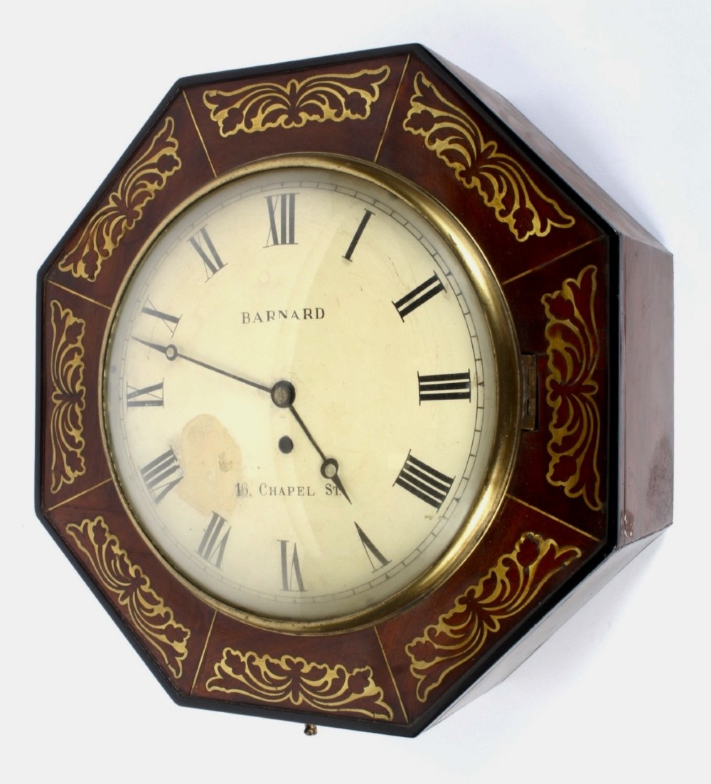 An octagonal Regency period wall clock in dark mahogany wood with intricate brass foliate inlay and a white dial featuring Roman numerals. View III