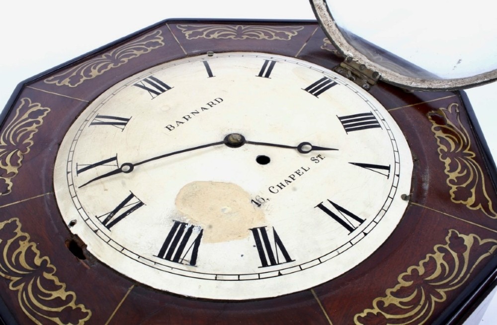 An octagonal Regency period wall clock in dark mahogany wood with intricate brass foliate inlay and a white dial featuring Roman numerals. View IV