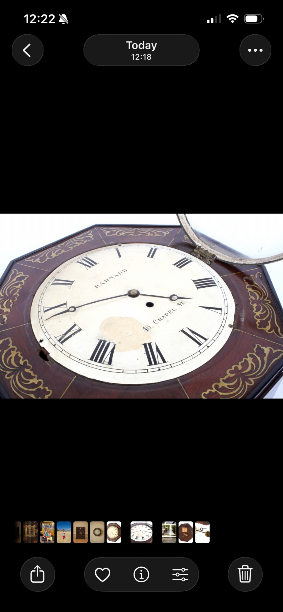 An octagonal Regency period wall clock in dark mahogany wood with intricate brass foliate inlay and a white dial featuring Roman numerals. View VIII