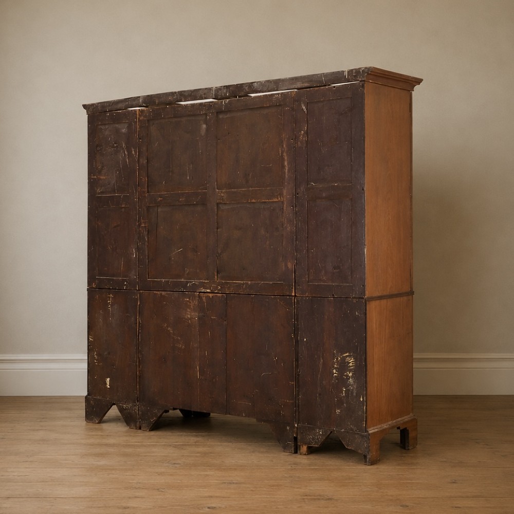 A large George III mahogany breakfront linen press wardrobe featuring central panelled doors above drawers, flanked by side cupboards on bracket feet. View XI