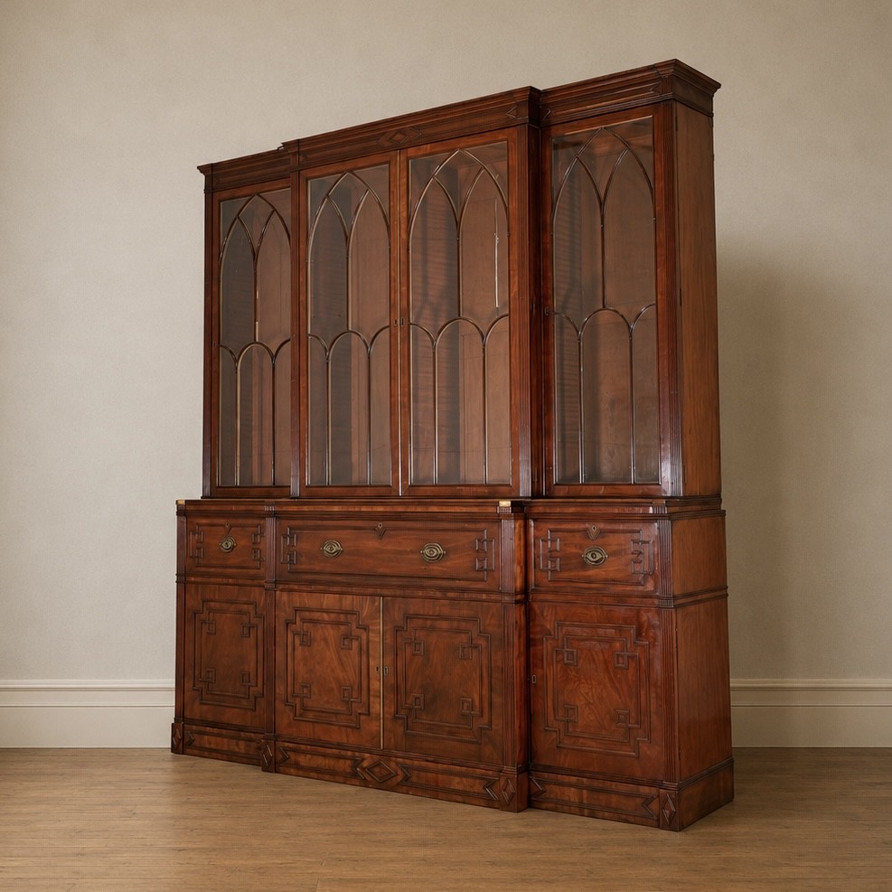 A large George IV mahogany breakfront library bookcase featuring gothic astragal glazed upper doors above drawers and cupboard doors with geometric moulding. View III