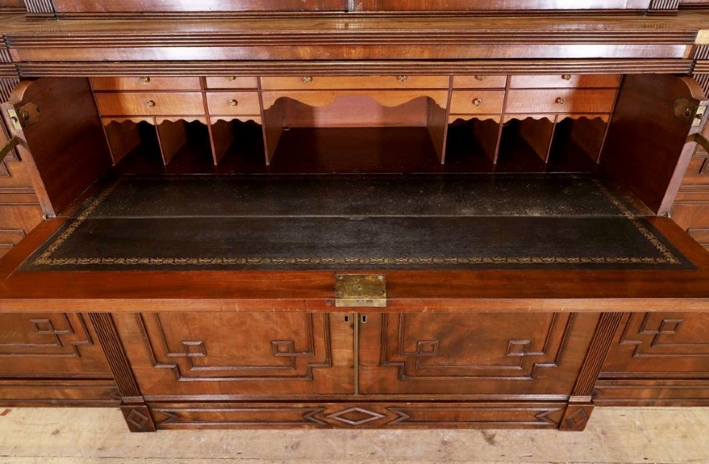 A large George IV mahogany breakfront library bookcase featuring gothic astragal glazed upper doors above drawers and cupboard doors with geometric moulding. View V
