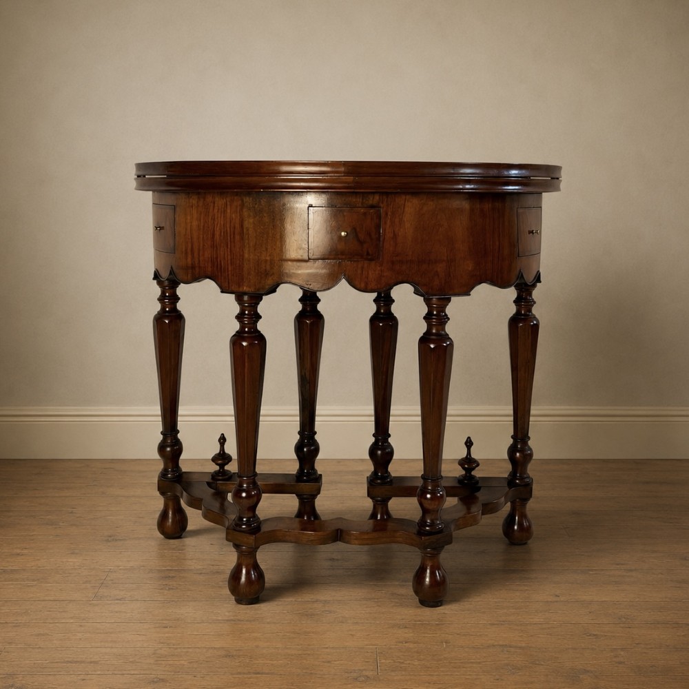 A Victorian figured walnut demi-lune card table featuring a scalloped apron, small frieze drawers, multiple turned legs, and a shaped stretcher base. View XV