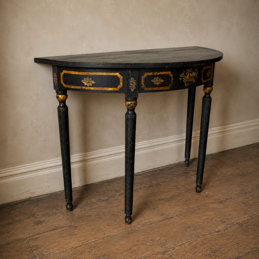 A Regency period semi-circular console table painted black with gold-gilded classical panel motifs and four slender turned legs. View XII