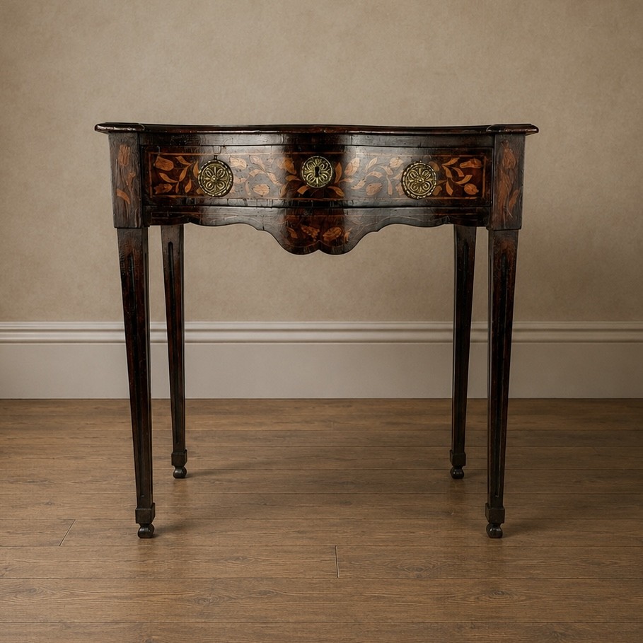 An 18th-century Dutch walnut side table featuring a serpentine front, floral marquetry inlay, a single drawer, and four square tapered legs. View II
