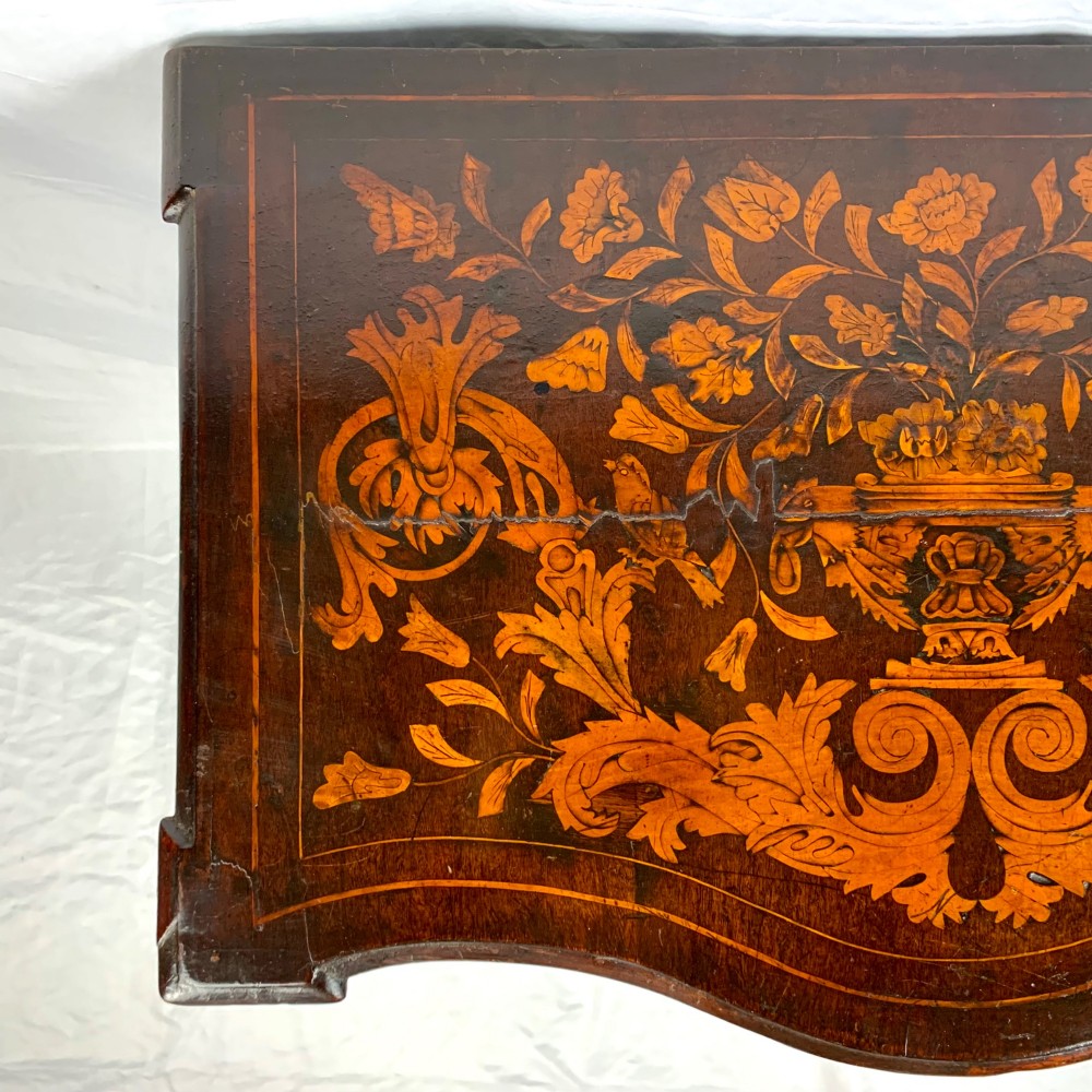 An 18th-century Dutch walnut side table featuring a serpentine front, floral marquetry inlay, a single drawer, and four square tapered legs. View IV