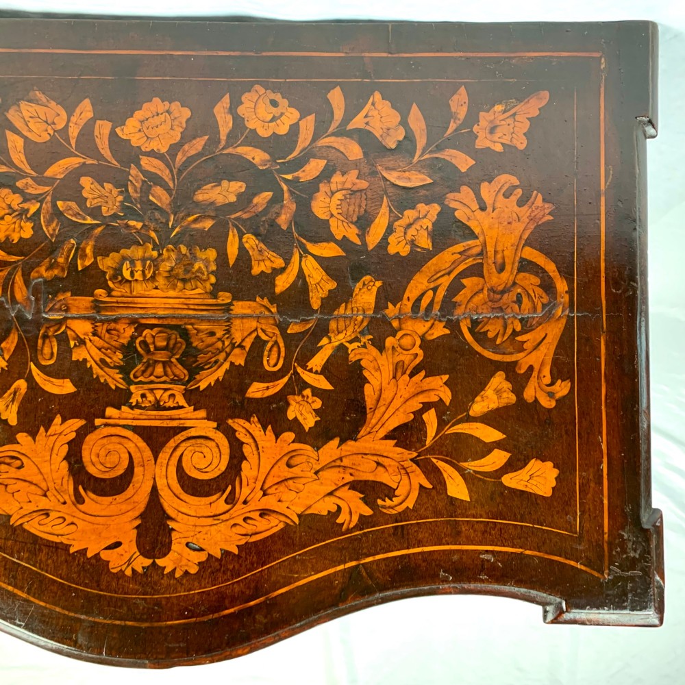 An 18th-century Dutch walnut side table featuring a serpentine front, floral marquetry inlay, a single drawer, and four square tapered legs. View V