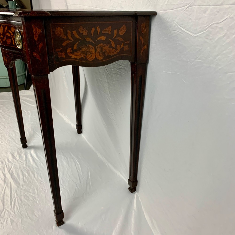 An 18th-century Dutch walnut side table featuring a serpentine front, floral marquetry inlay, a single drawer, and four square tapered legs. View VII