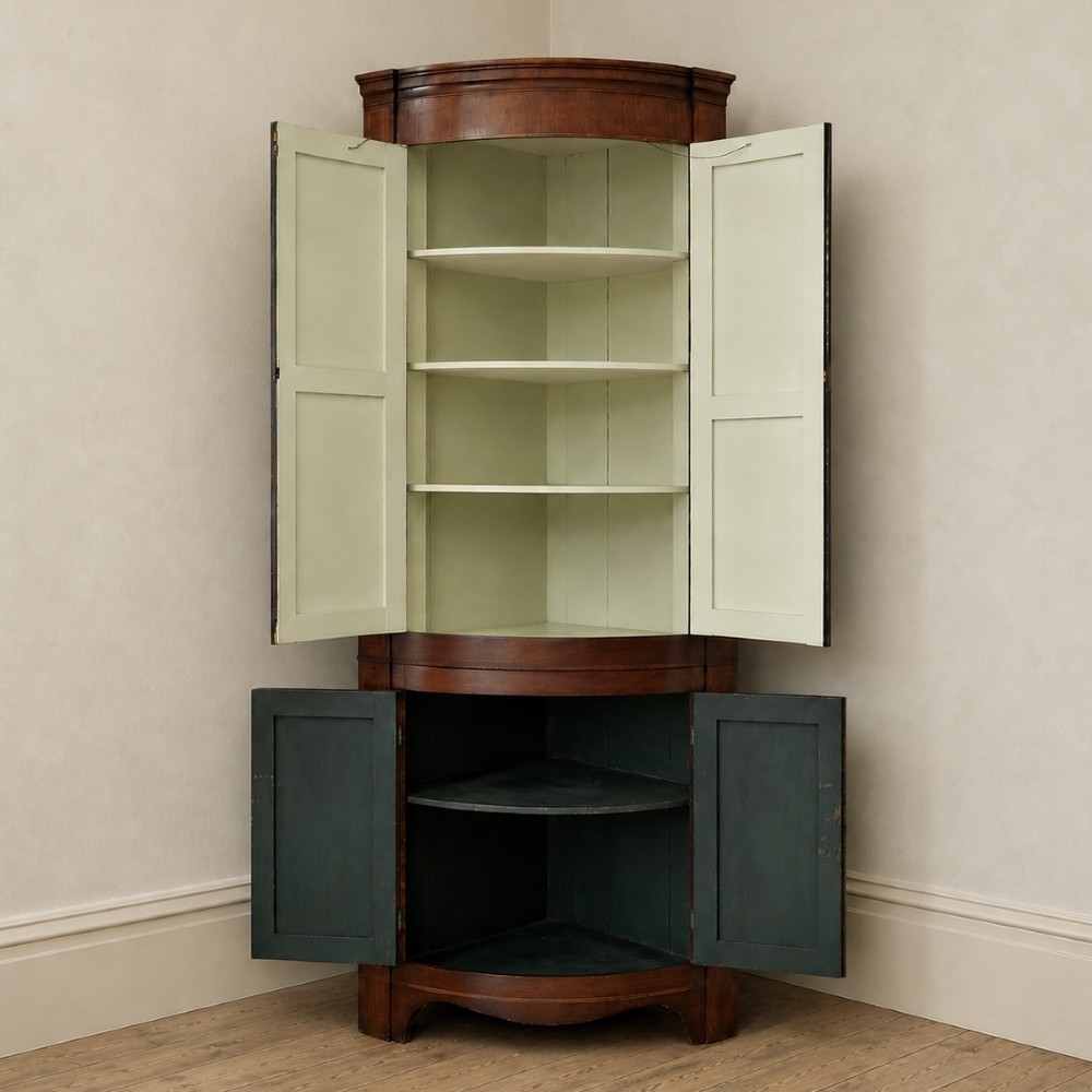 A tall Georgian mahogany bowfront corner cupboard featuring two upper curved doors, two lower curved doors, and fine line inlay. View XV