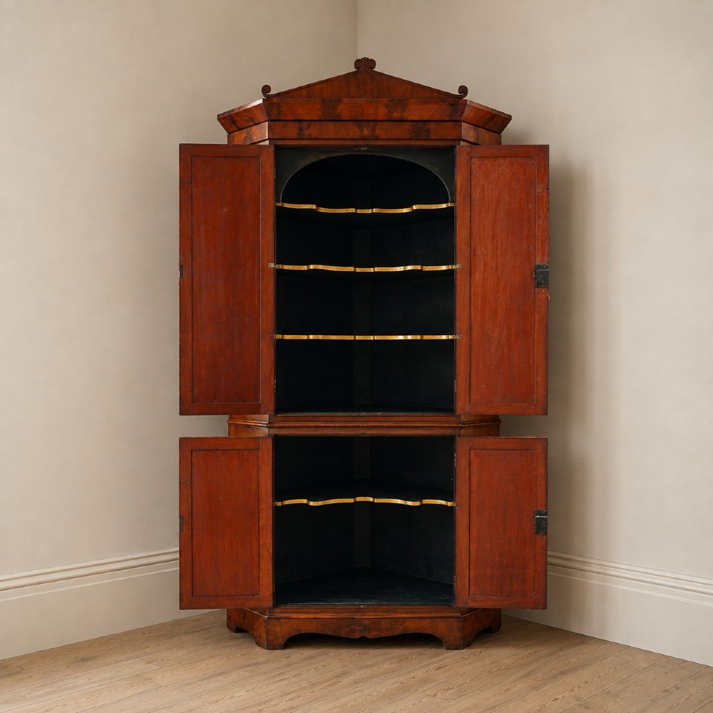 A tall, two-tier William IV corner cupboard crafted from dark plum pudding mahogany, featuring panelled double doors on both top and bottom sections with carved detail and a pediment top. View XIII