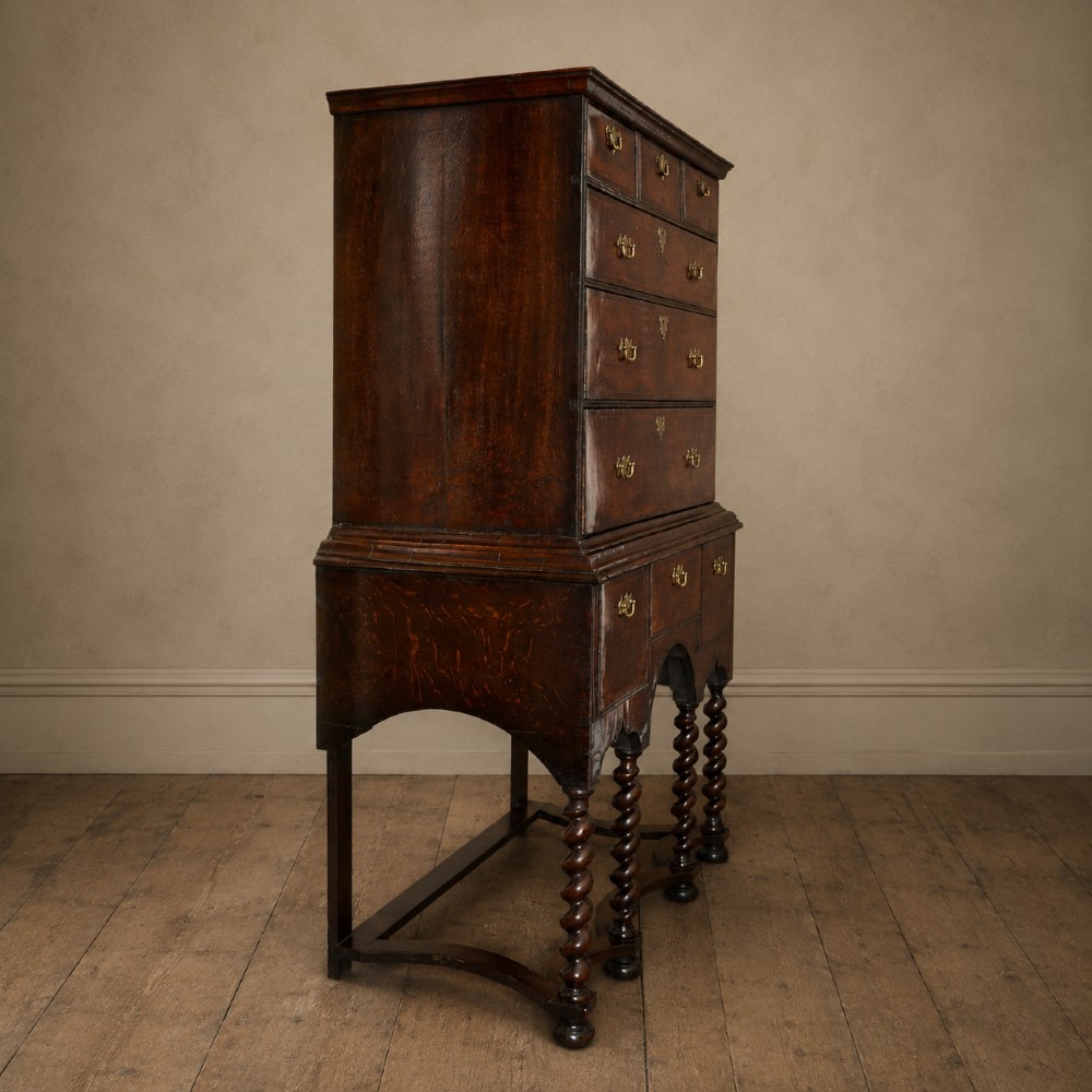 A George I period figured walnut chest on stand featuring engraved brass escutcheons and six barley-twist legs. View IV