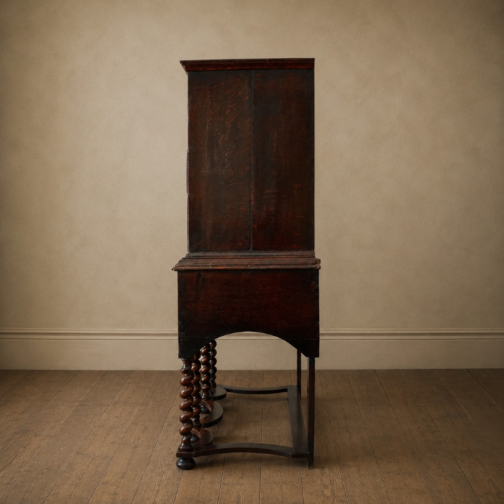 A George I period figured walnut chest on stand featuring engraved brass escutcheons and six barley-twist legs. View V