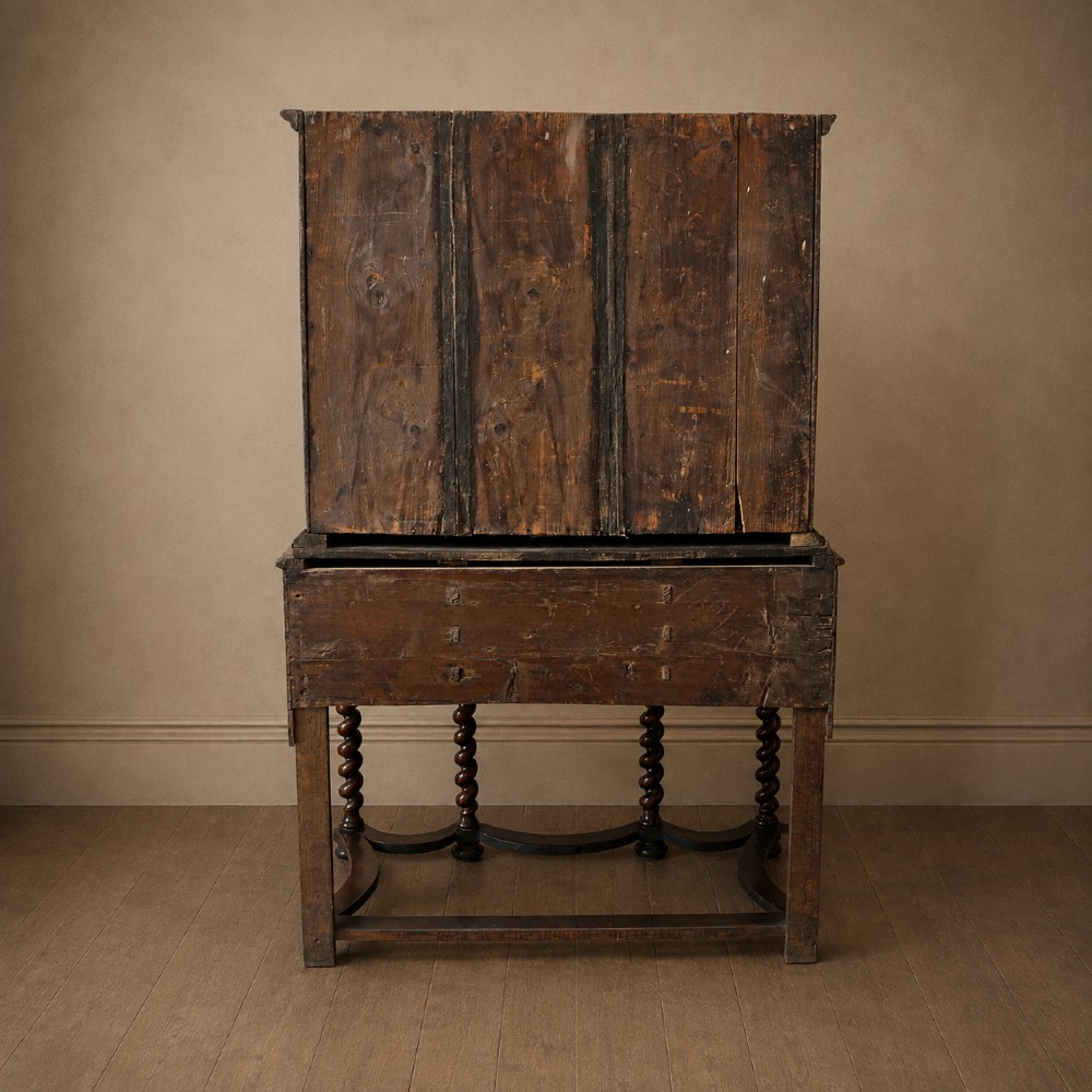 A George I period figured walnut chest on stand featuring engraved brass escutcheons and six barley-twist legs. View VI