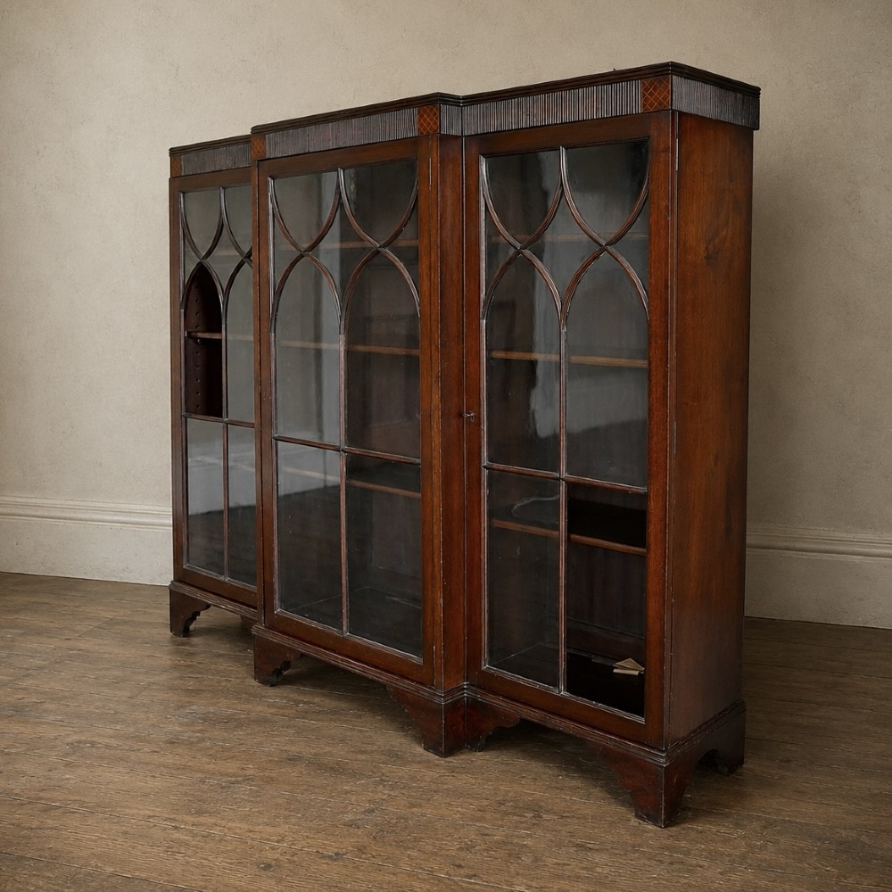 A large Victorian dark mahogany breakfront glazed bookcase featuring three doors with Gothic arch astragal glazing bars and a fluted cornice. View XIV