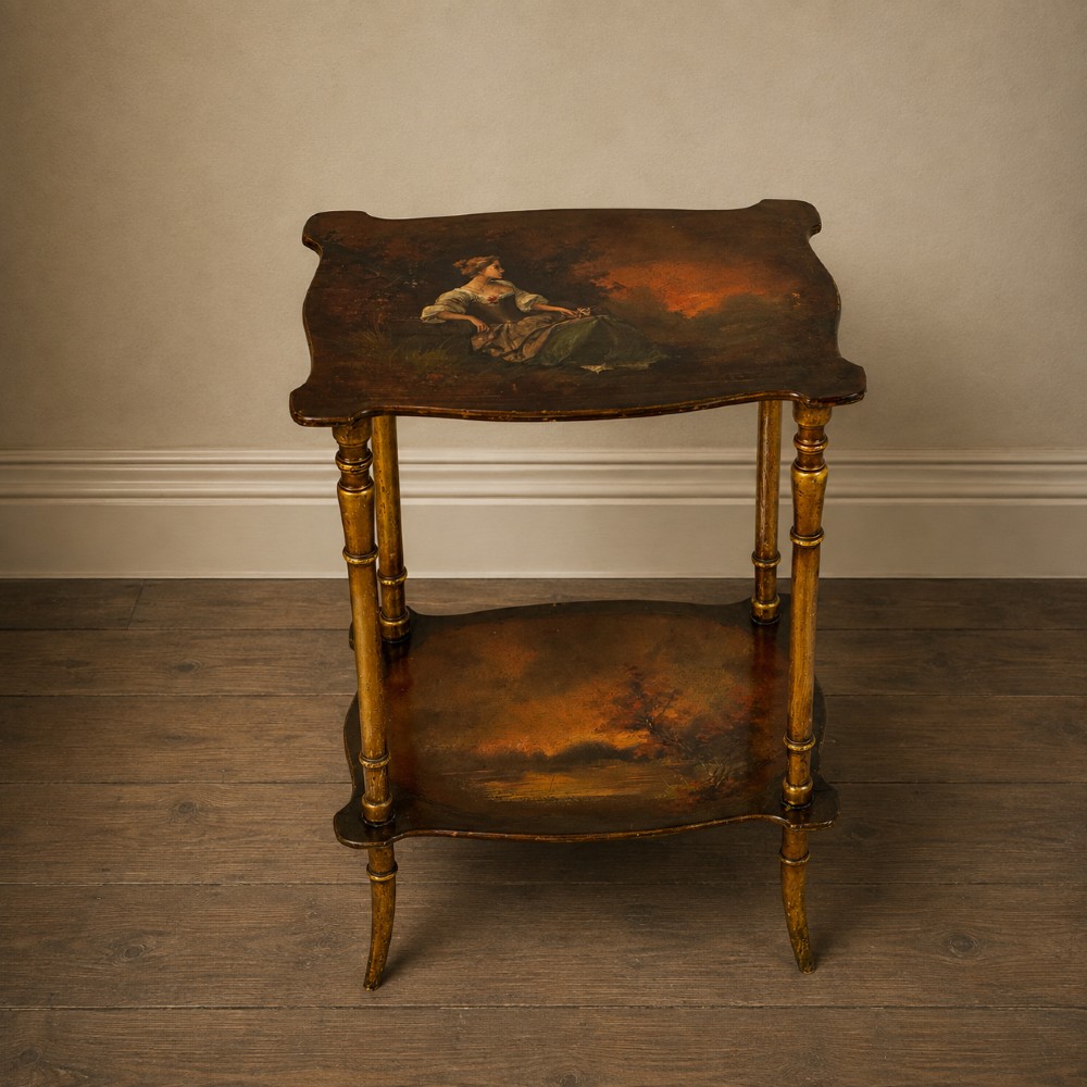 A two-tier continental side table featuring hand-painted figural scenes on shaped wooden surfaces, supported by turned gilt legs. View II