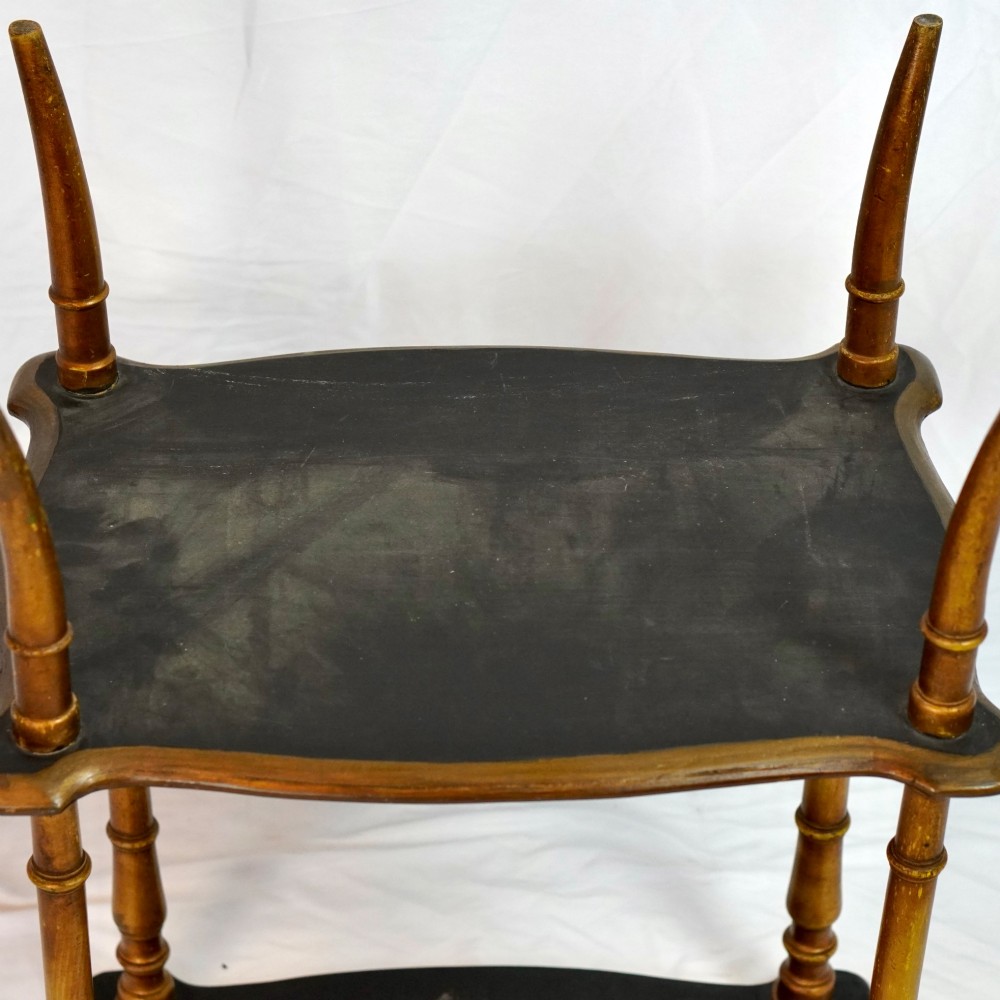 A two-tier continental side table featuring hand-painted figural scenes on shaped wooden surfaces, supported by turned gilt legs. View X