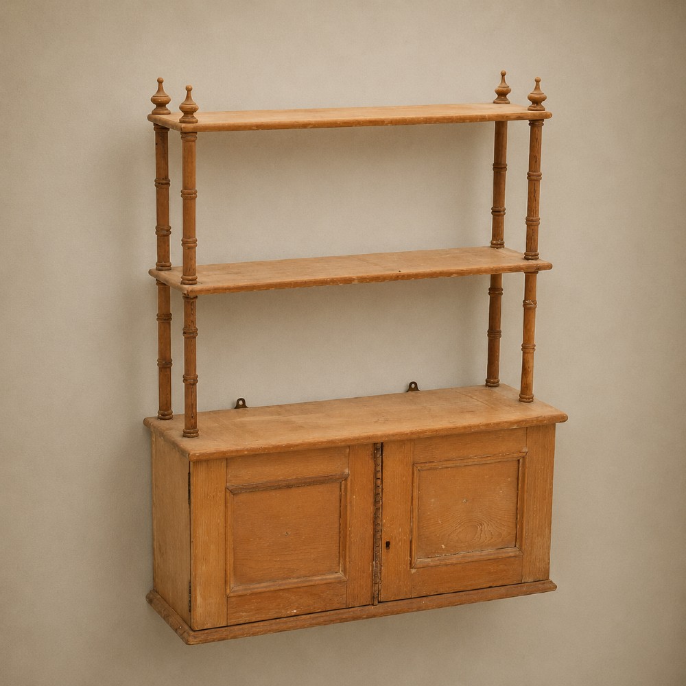 A 19th-century wall-mounted pine rack featuring two open upper shelves supported by turned spindles with finials above an enclosed double-door cupboard. View II