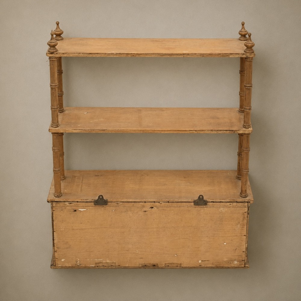 A 19th-century wall-mounted pine rack featuring two open upper shelves supported by turned spindles with finials above an enclosed double-door cupboard. View V