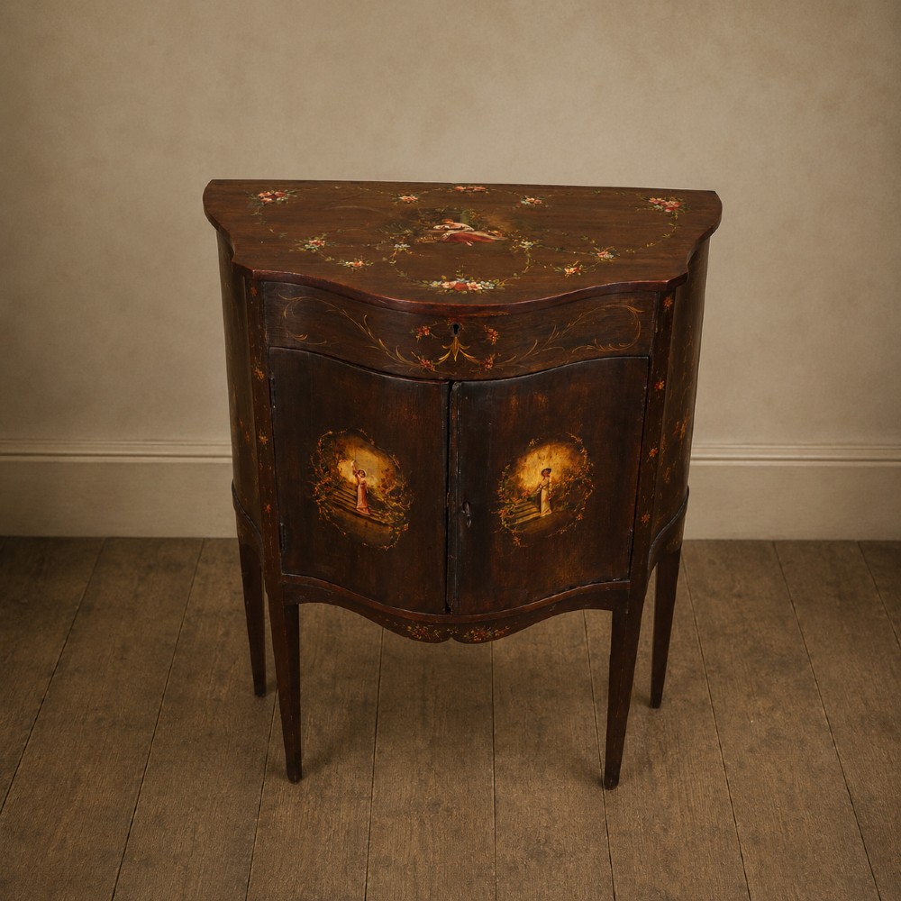 A dark mahogany serpentine-front side cabinet with hand-painted floral swags and figurative door panel vignettes resting on slender square tapered legs.
