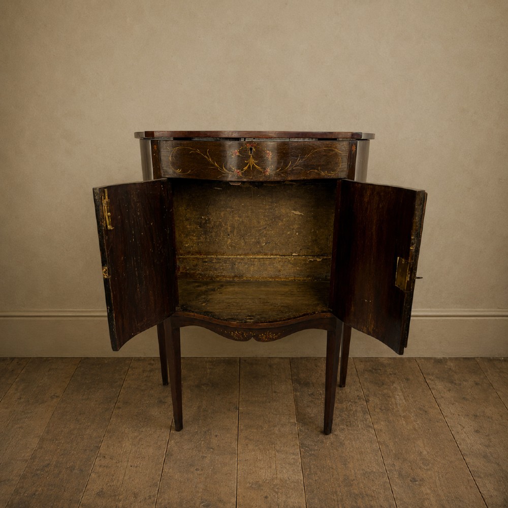 A dark mahogany serpentine-front side cabinet with hand-painted floral swags and figurative door panel vignettes resting on slender square tapered legs. View VIII