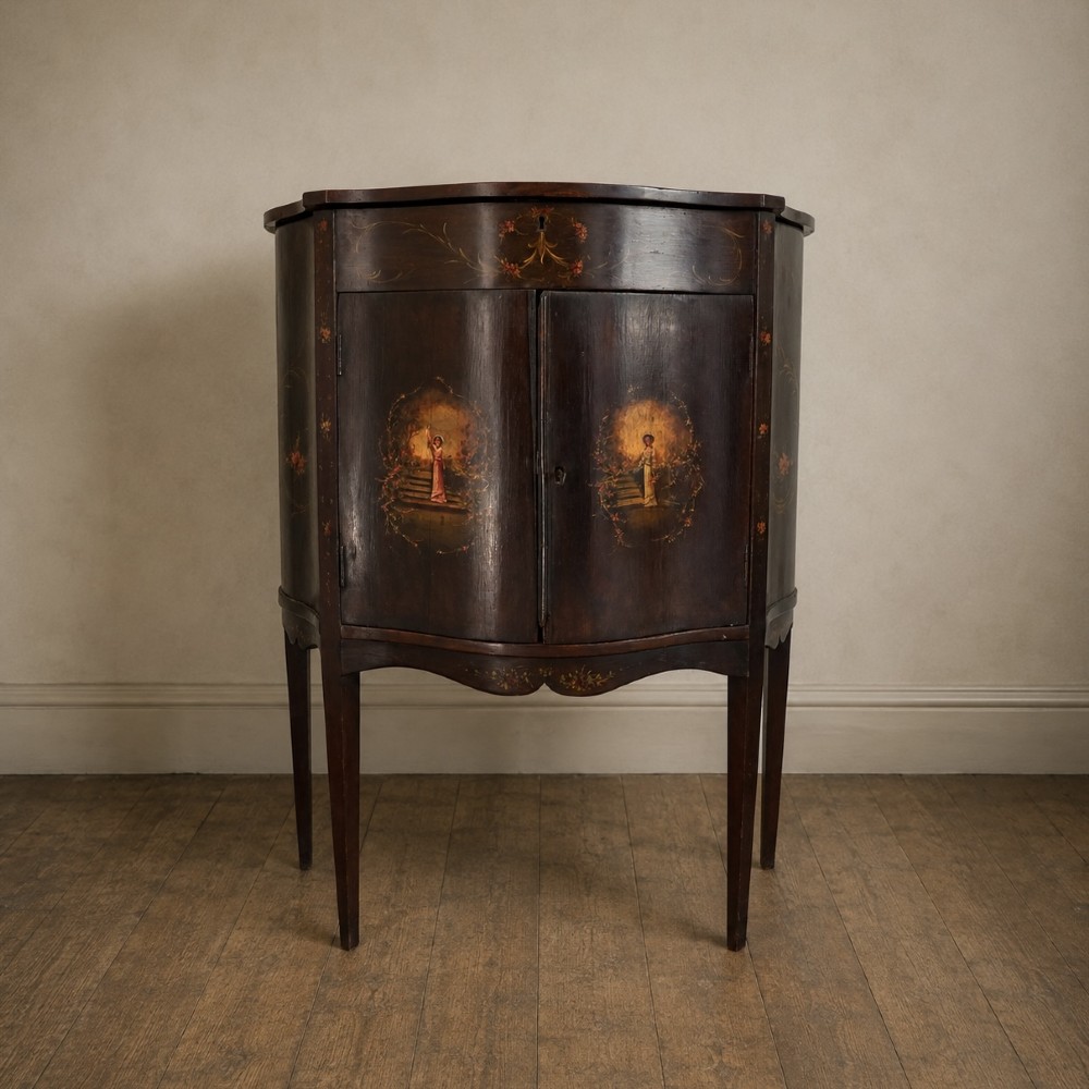 A dark mahogany serpentine-front side cabinet with hand-painted floral swags and figurative door panel vignettes resting on slender square tapered legs. View IX