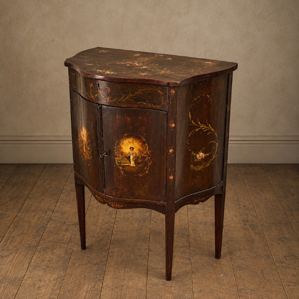 A dark mahogany serpentine-front side cabinet with hand-painted floral swags and figurative door panel vignettes resting on slender square tapered legs. View X