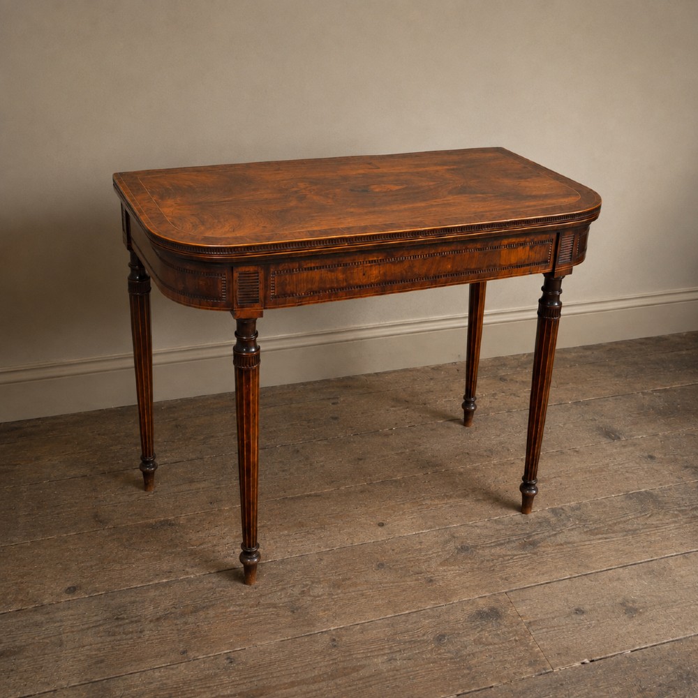 An antique Regency rosewood fold-over card table featuring burr yew crossbanding, a rectangular top with rounded corners, and slender fluted tapered legs. View IV