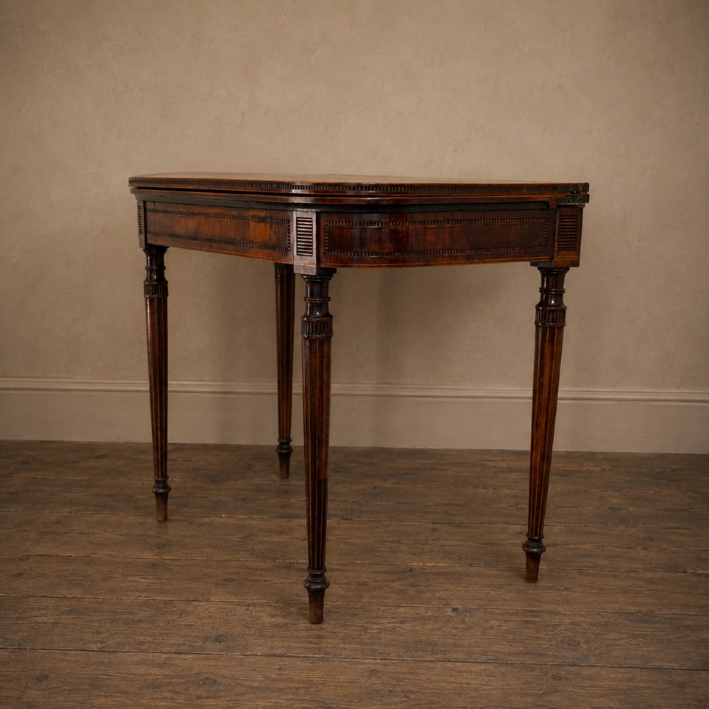 An antique Regency rosewood fold-over card table featuring burr yew crossbanding, a rectangular top with rounded corners, and slender fluted tapered legs. View IX