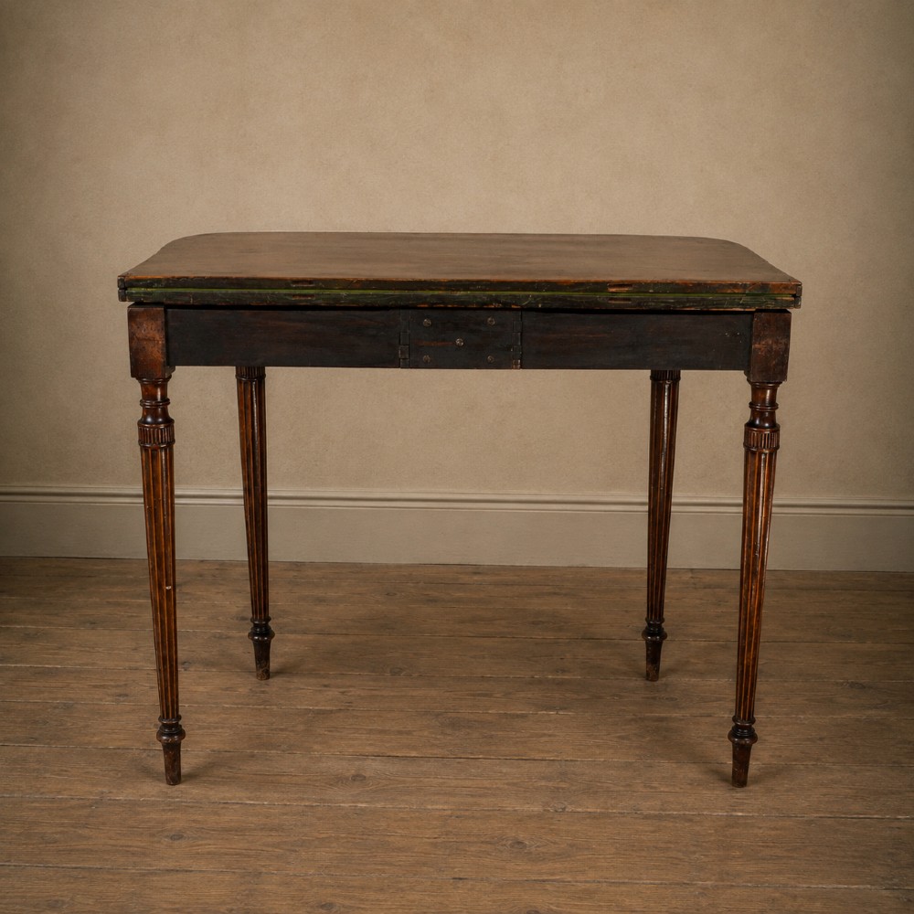 An antique Regency rosewood fold-over card table featuring burr yew crossbanding, a rectangular top with rounded corners, and slender fluted tapered legs. View X