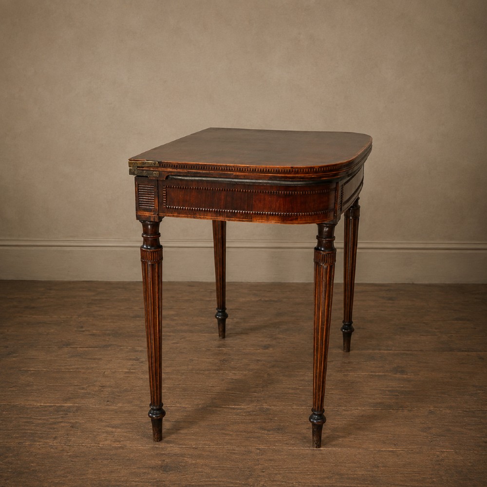 An antique Regency rosewood fold-over card table featuring burr yew crossbanding, a rectangular top with rounded corners, and slender fluted tapered legs. View XI