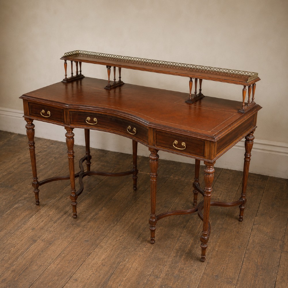 A Victorian rosewood writing desk featuring a brass gallery shelf, three drawers with brass handles, turned fluted legs, and curved stretchers. View XIII