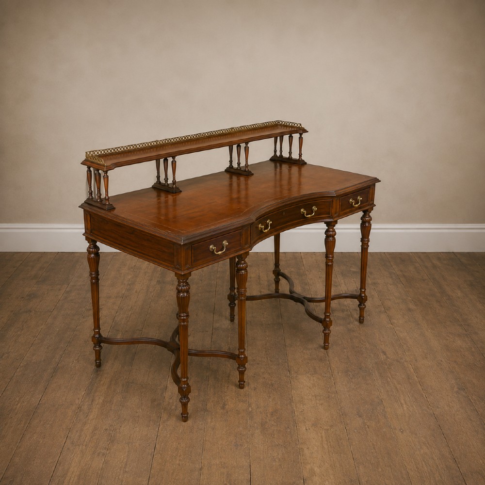 A Victorian rosewood writing desk featuring a brass gallery shelf, three drawers with brass handles, turned fluted legs, and curved stretchers. View XIV