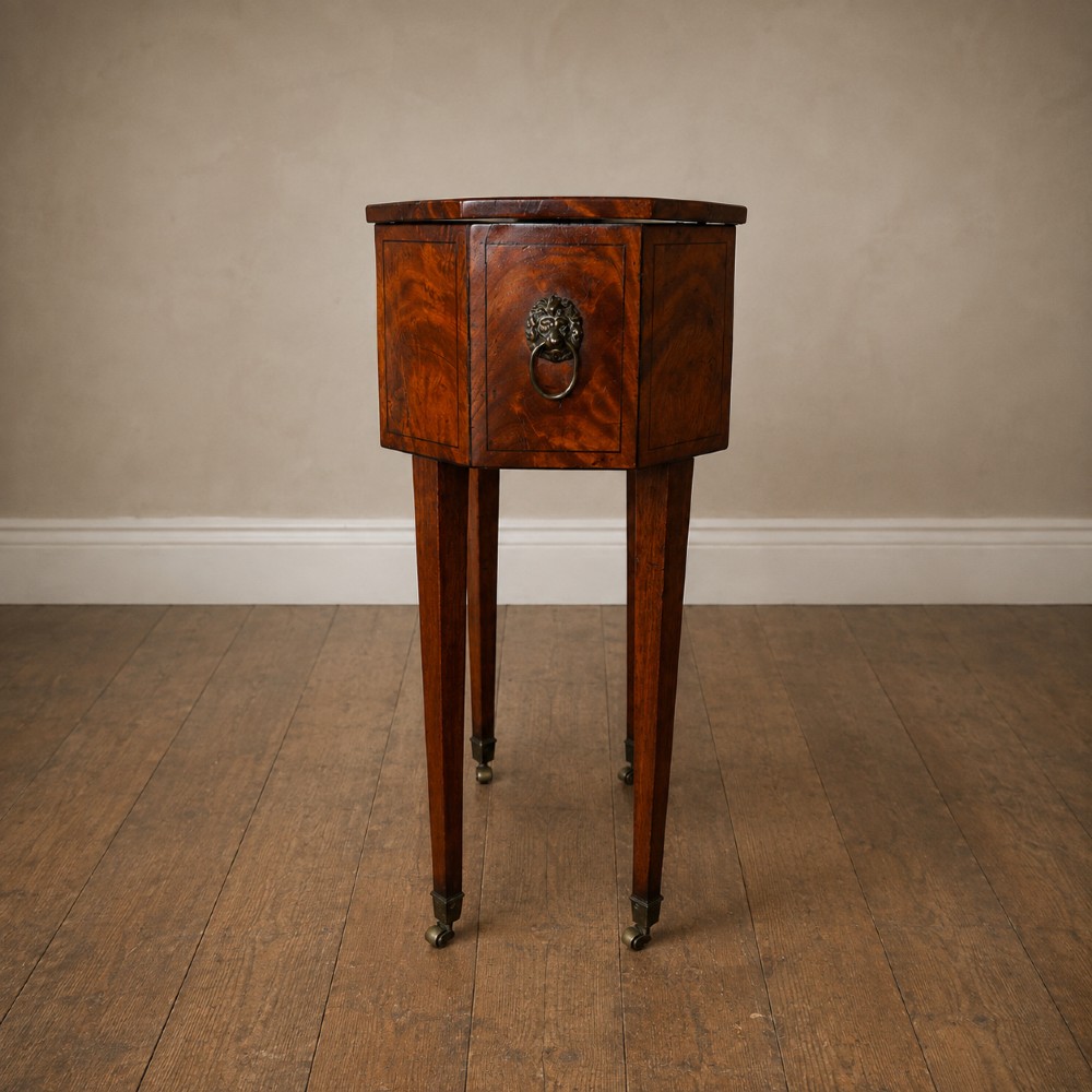 An octagonal George III satinwood work table with two drawers, lion mask ring handles, and tapered legs ending in brass castors. View VII