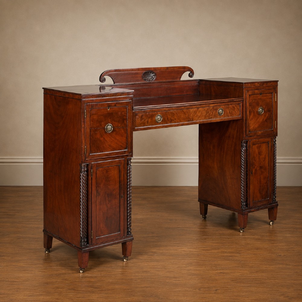 A Regency figured mahogany pedestal sideboard with spiral-turned columns, brass drop handles, and a central carved splashback. View II