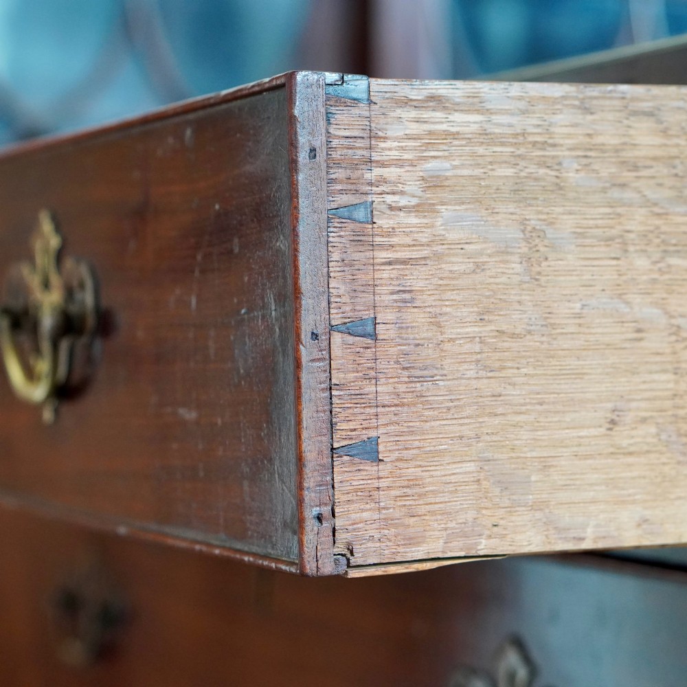 A George II dark mahogany straight-front chest featuring four graduated long drawers with decorative brass swan-neck handles and bracket feet. View XII