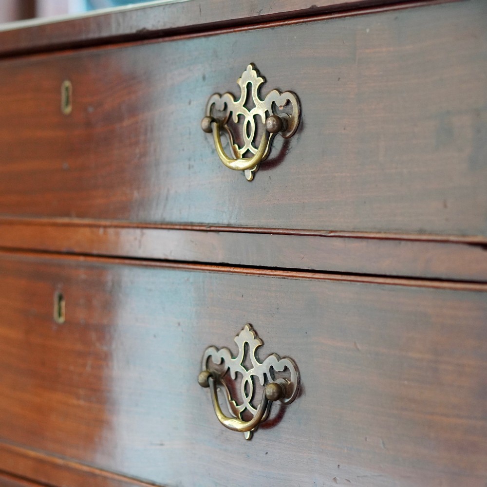 A George II dark mahogany straight-front chest featuring four graduated long drawers with decorative brass swan-neck handles and bracket feet. View XV